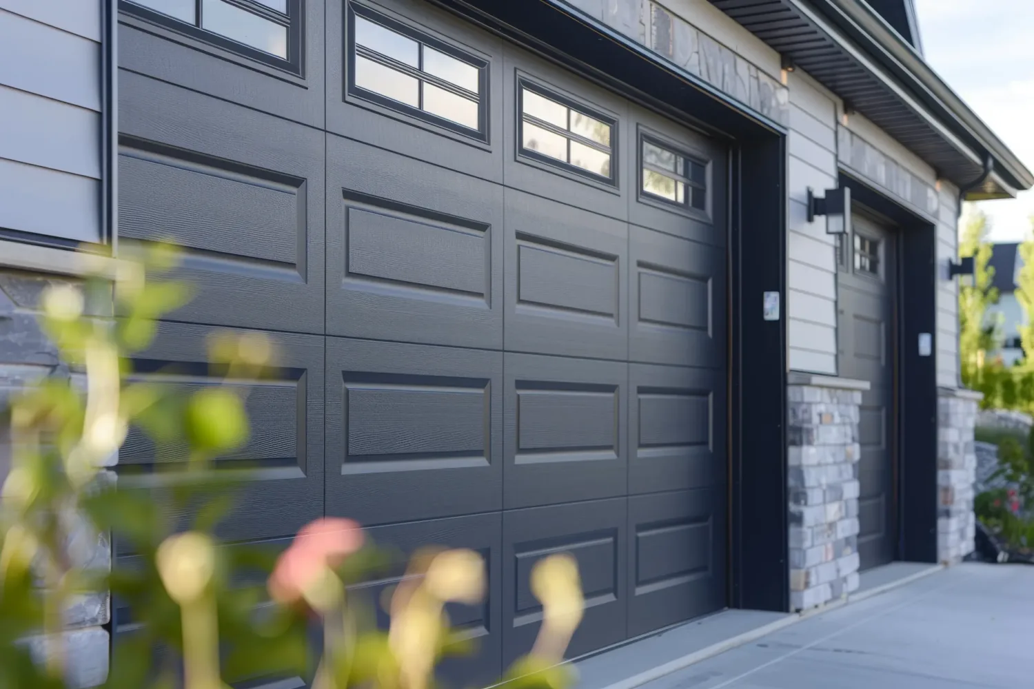 A close-up of a modern two-car garage. The garage is part of a stylish contemporary home, with a design that emphasizes simplicity and functionality