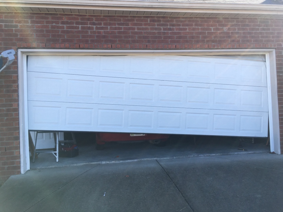 garage-door-off-track Garage doors installation. Workers installing Post Rail and Spring Installation / Assembly.