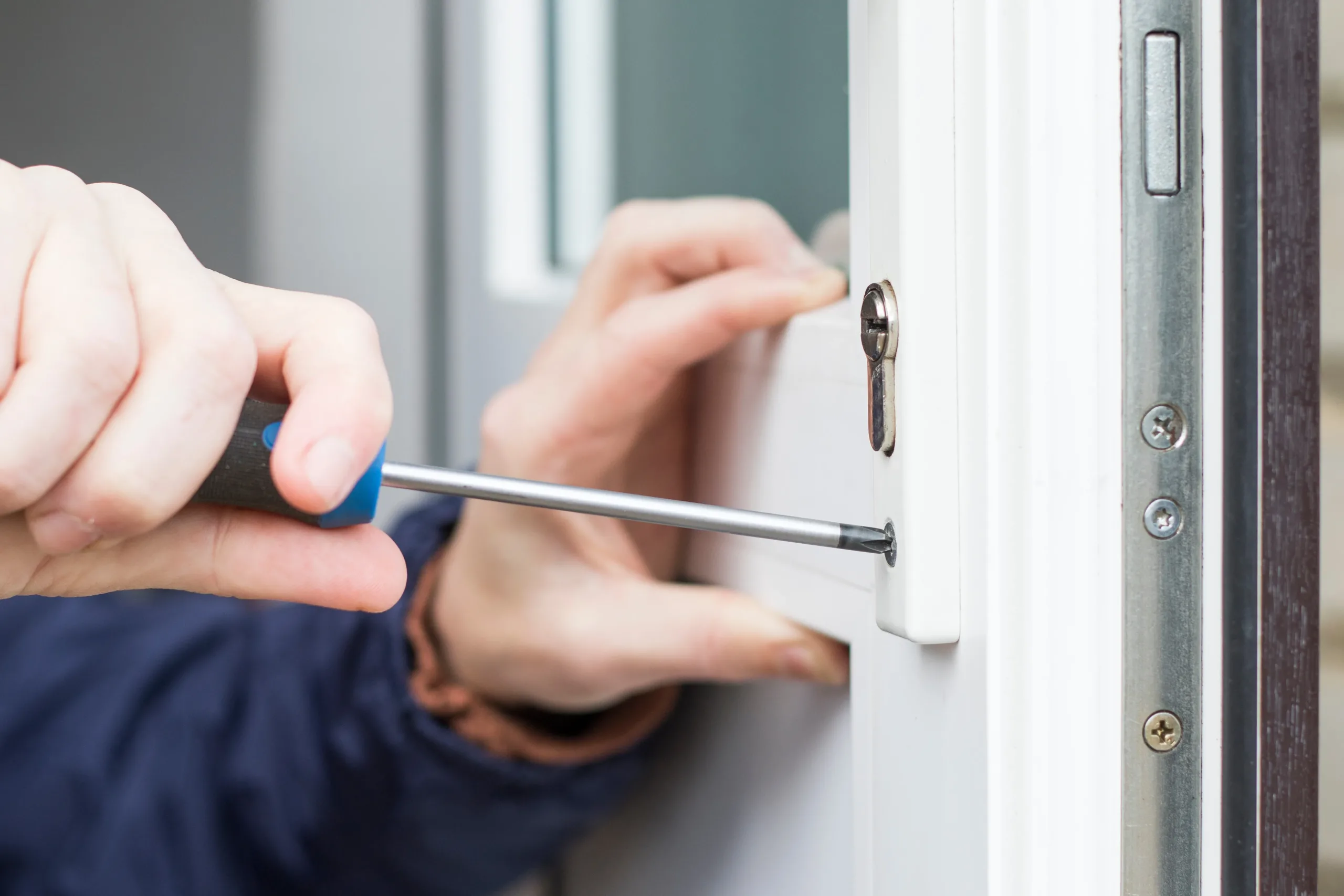 installing-entry-door Garage doors installation. Workers installing Post Rail and Spring Installation / Assembly.