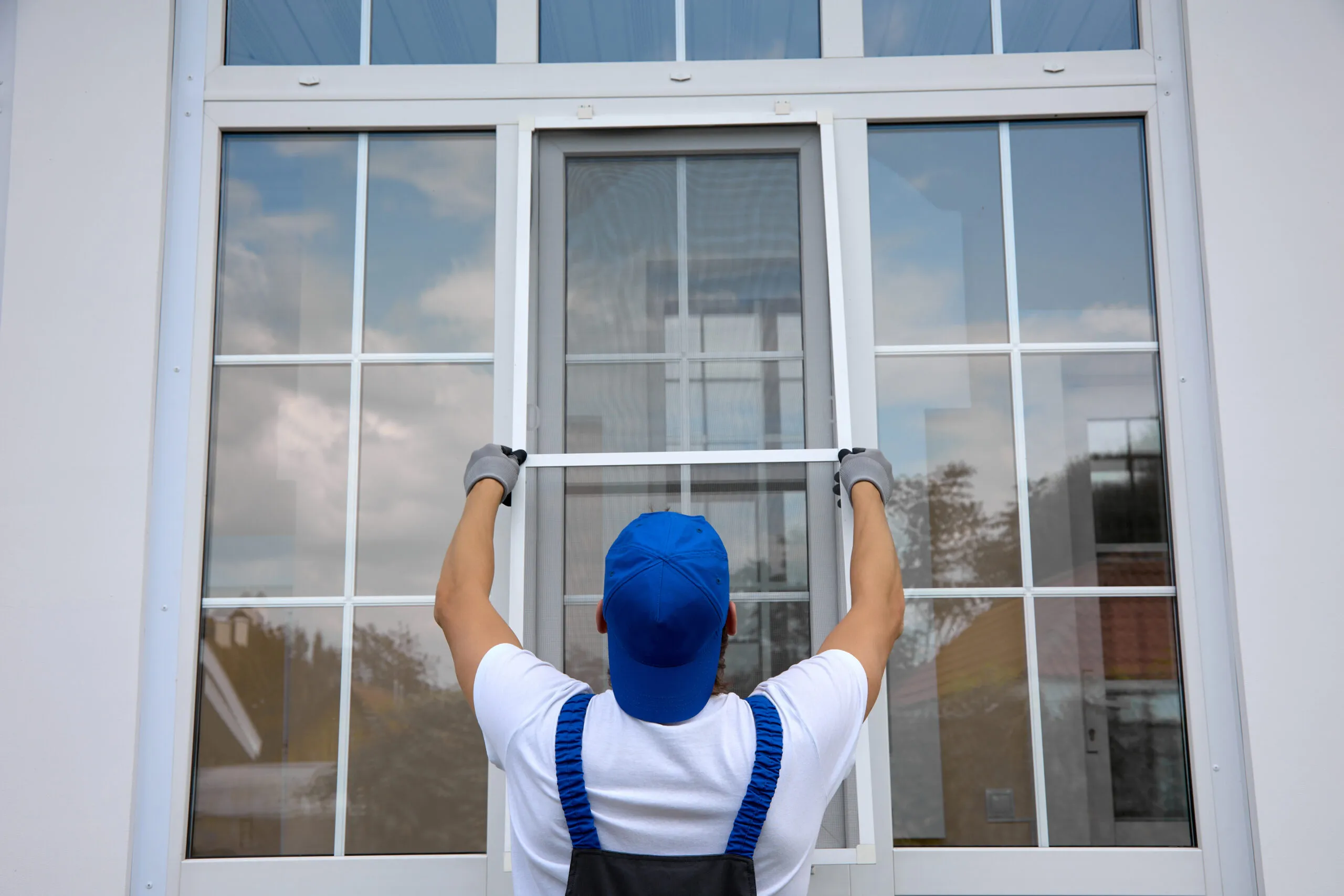 Garage doors installation. Workers installing  Post Rail and Spring Installation / Assembly.