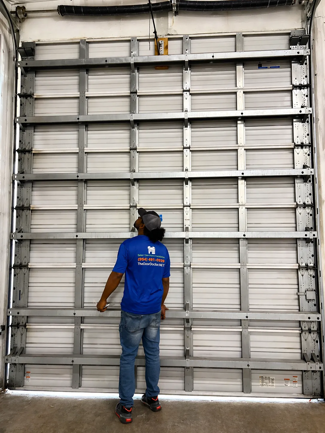 Garage doors installation. Workers installing Post Rail and Spring Installation / Assembly.